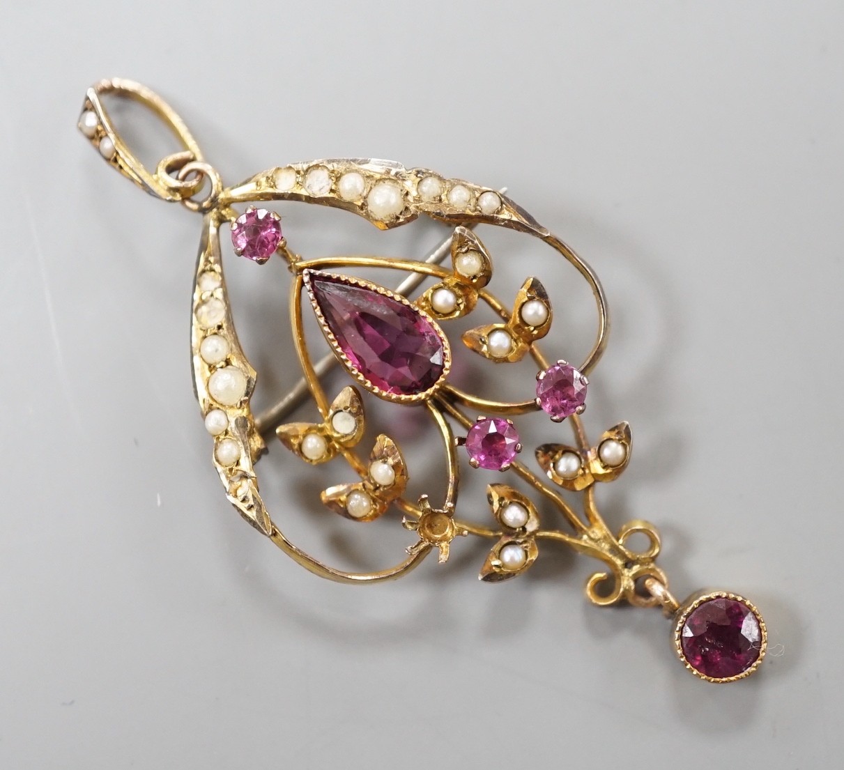 An Edwardian yellow metal, garnet, amethyst? and seed pearl set drop pendant, overall 51mm, gross weight 3.3 grams.